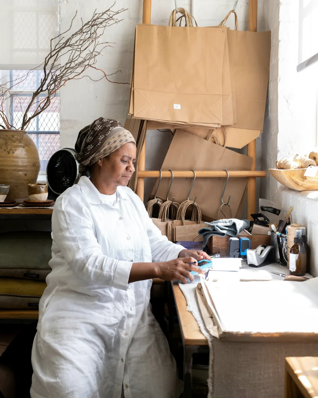 A shop owner packing an order on a wooden table