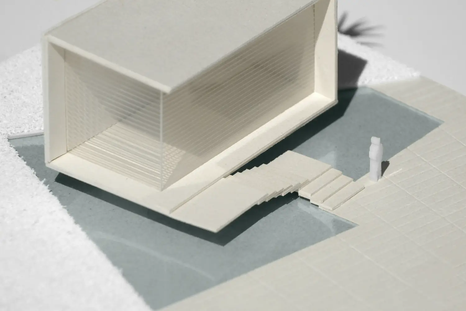 A white architectural model of a house on a table